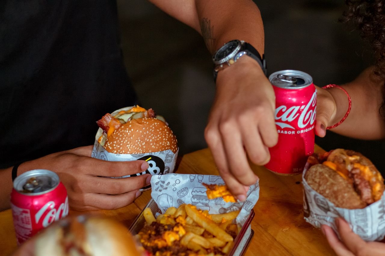 Enjoying delicious burgers and fries with friends in a casual setting.