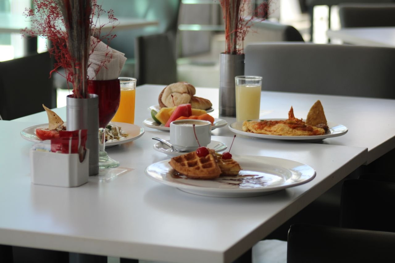 A beautifully arranged breakfast table with waffles, fruits, and drinks in a Zacatecas restaurant.